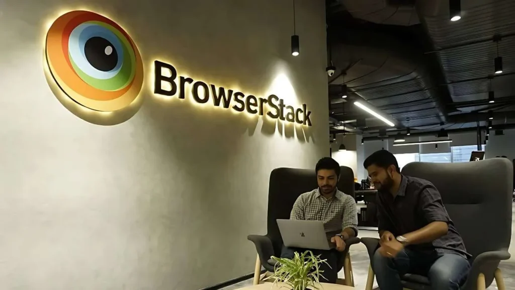 BrowserStack office interior with illuminated logo and employees working on laptop