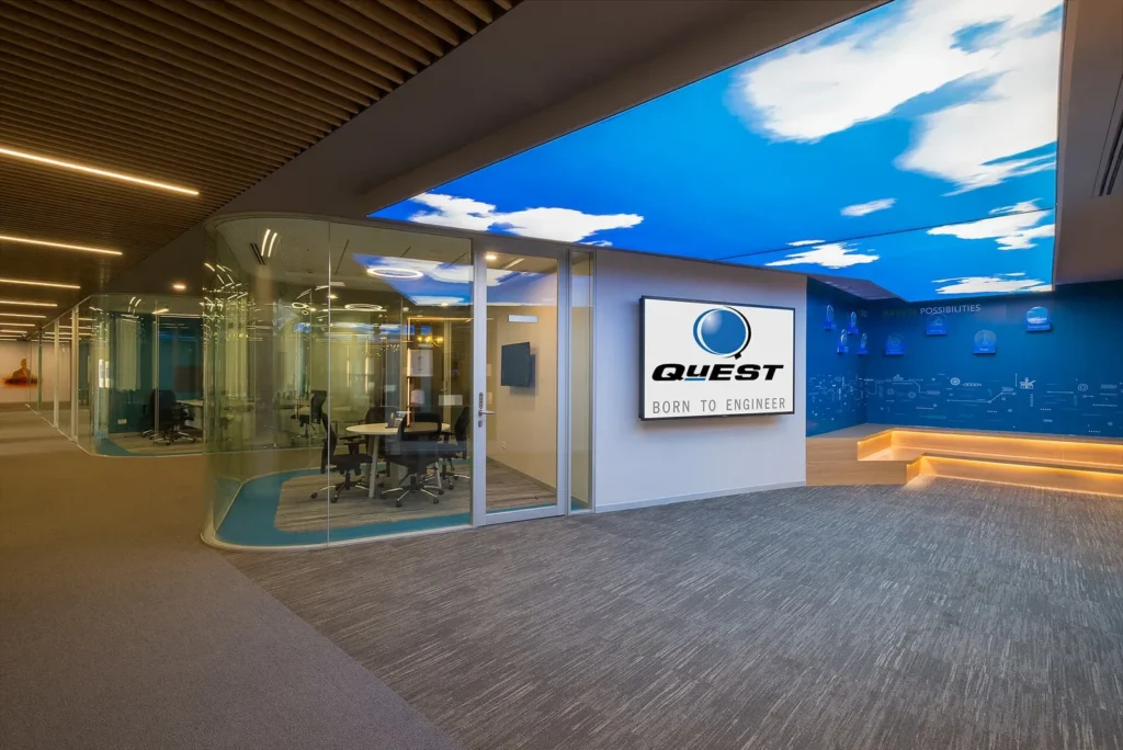 Quest Global office interior with glass meeting rooms and branded wall display