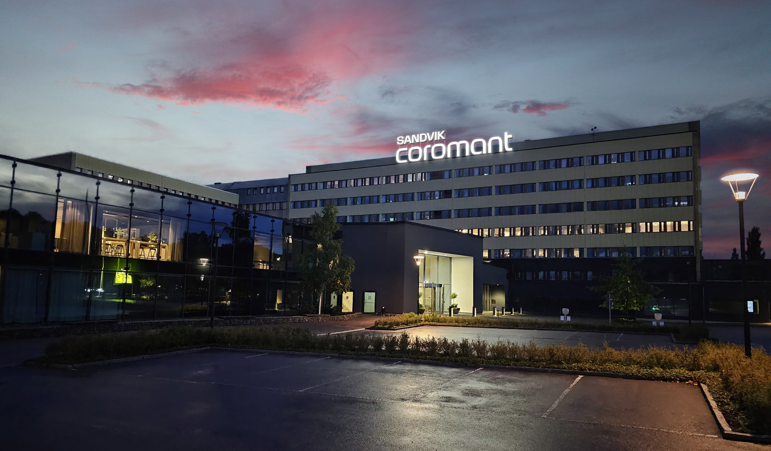 Sandvik Coromant office building illuminated at dusk with sunset sky