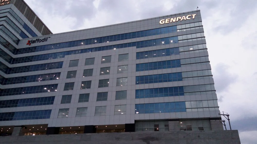 Genpact office building exterior with company logo on glass facade